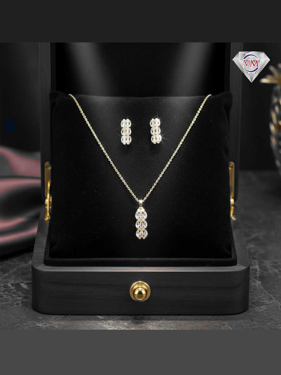 Gold plated drop pendant and earrings featuring three vertically stacked marquise cut cubic zirconia clusters