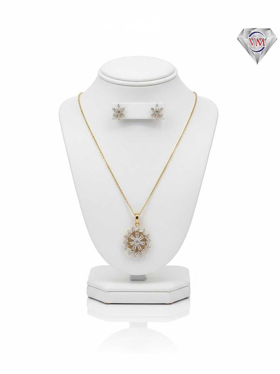 Gold plated wreath pendant and earrings with a sunburst center and baguette cut cubic zirconia border