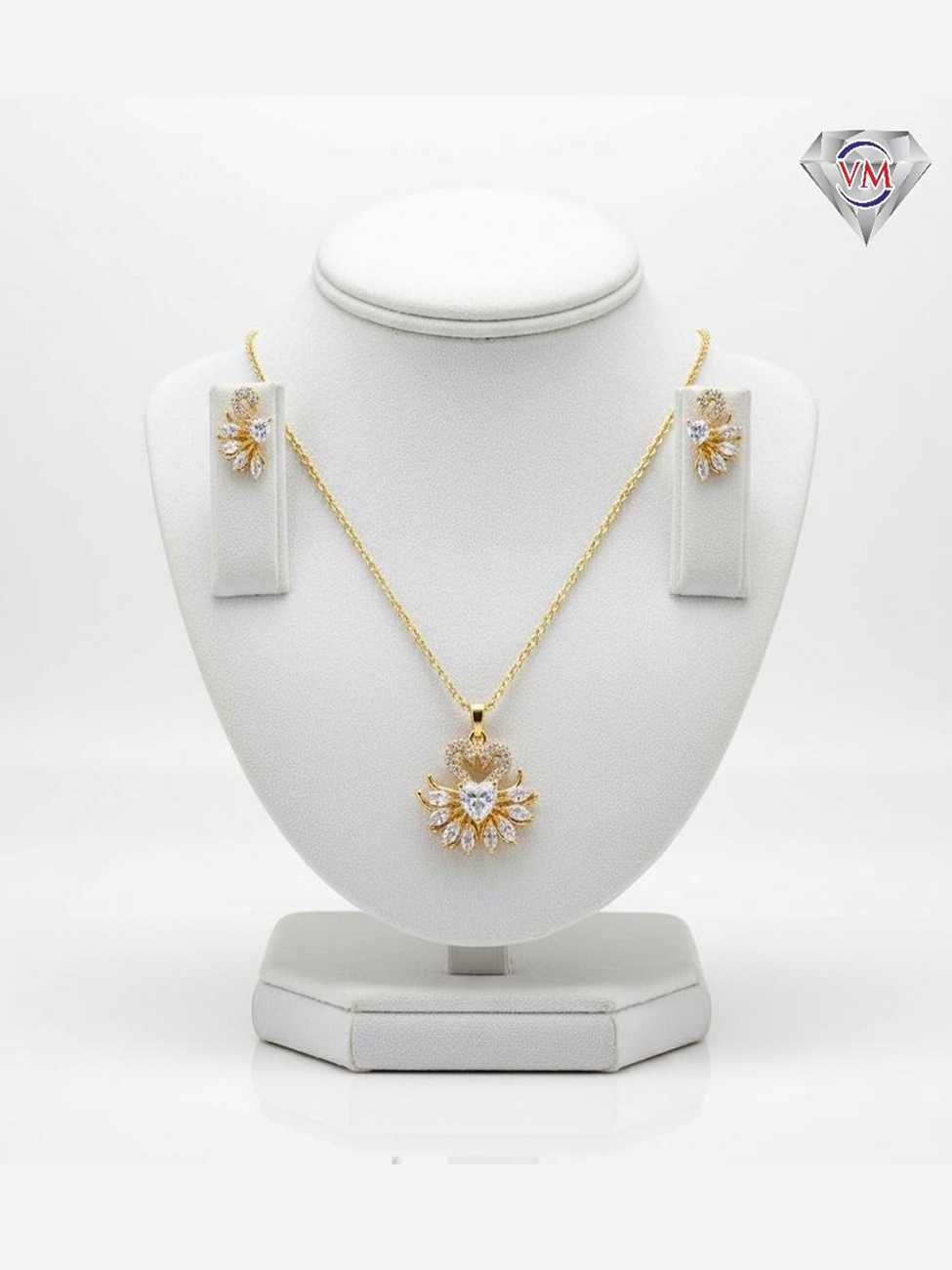 Gold plated pendant and earrings featuring a heart shaped center topped with a swan motif and marquise petals