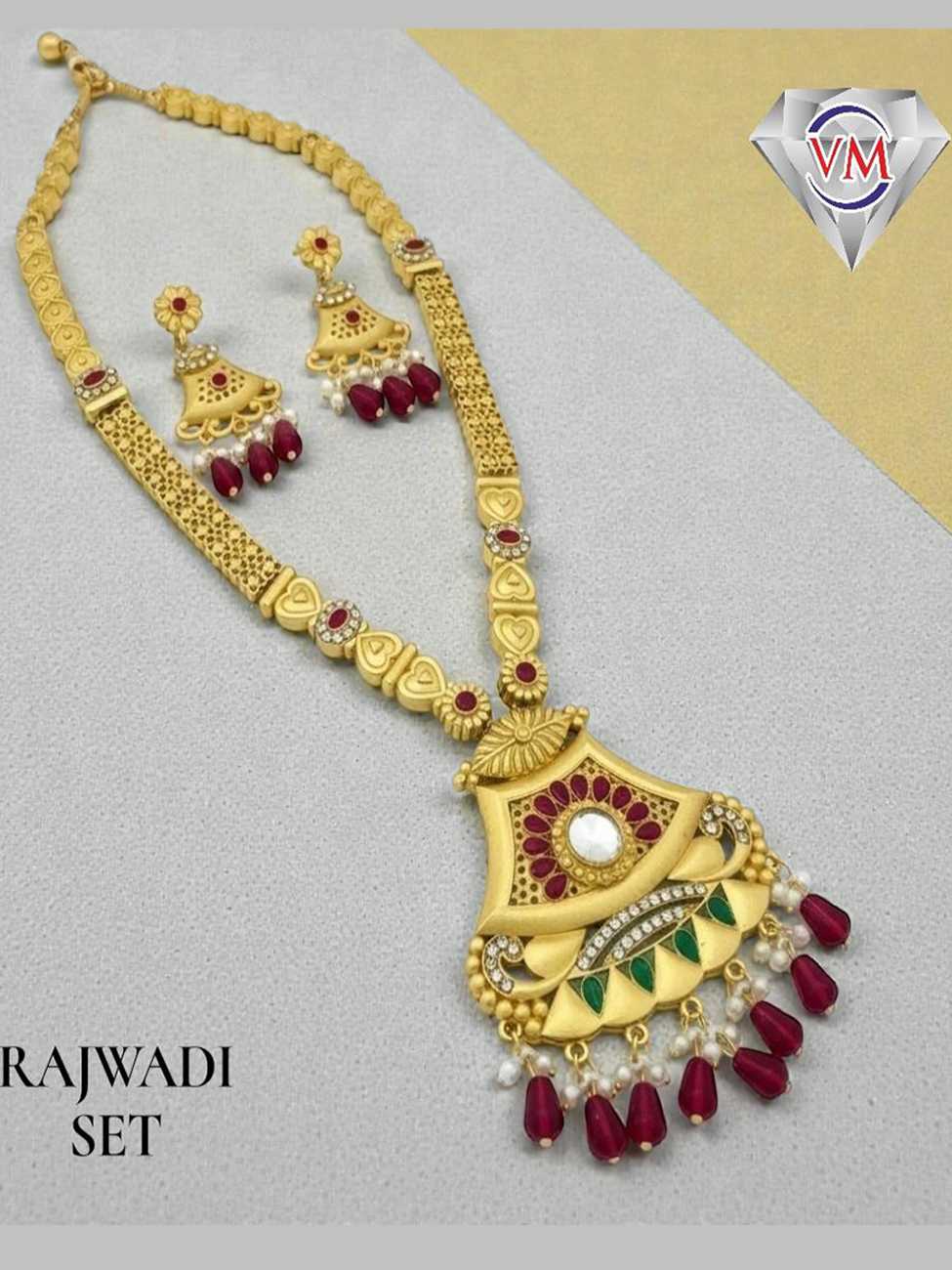 Handcrafted gold finish Rajwadi necklace set with fan motif pendant, kundan center stone, green enamel detailing and ruby bead drops