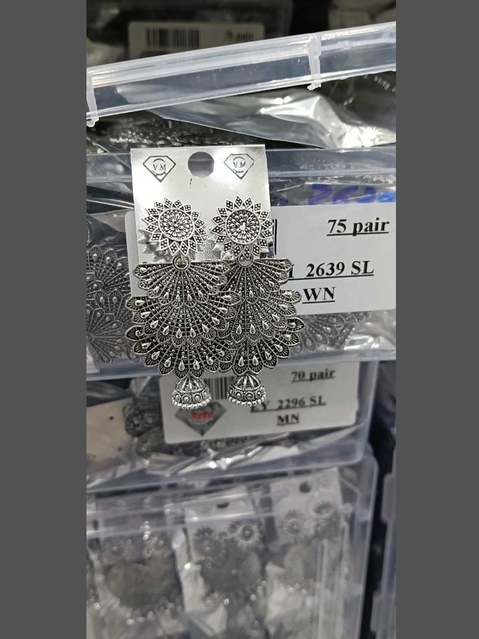 Large shield style oxidized silver earrings with peacock feather patterns and jhumka base.