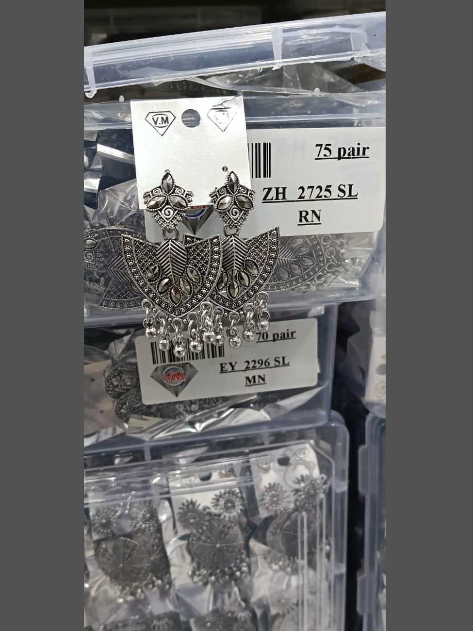 Oxidized silver shield shaped earrings featuring central leaf motifs and hanging silver beads