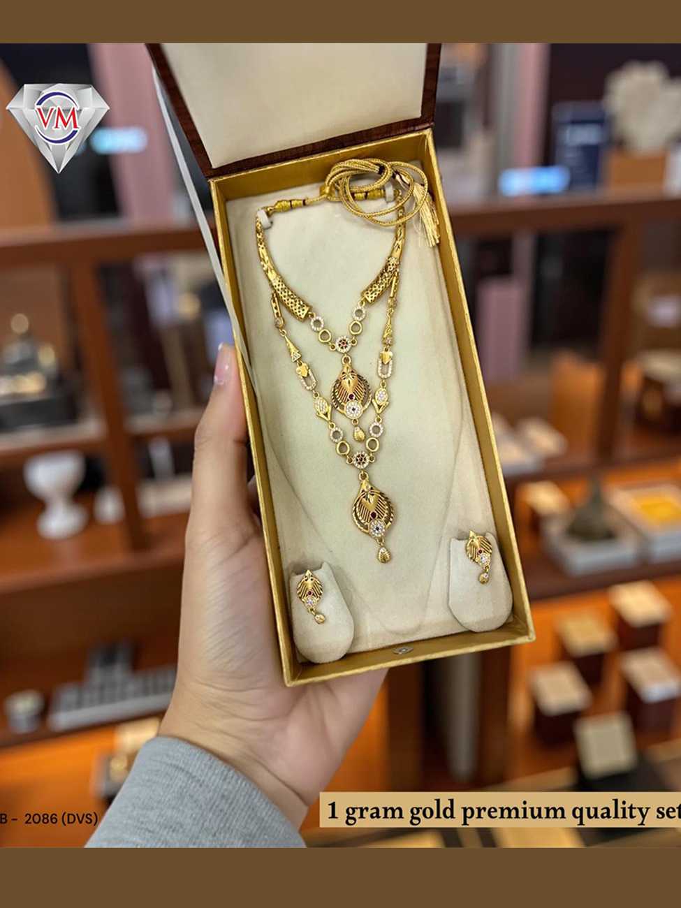 1 gram gold layered necklace set displayed in premium jewellery box with matching earrings