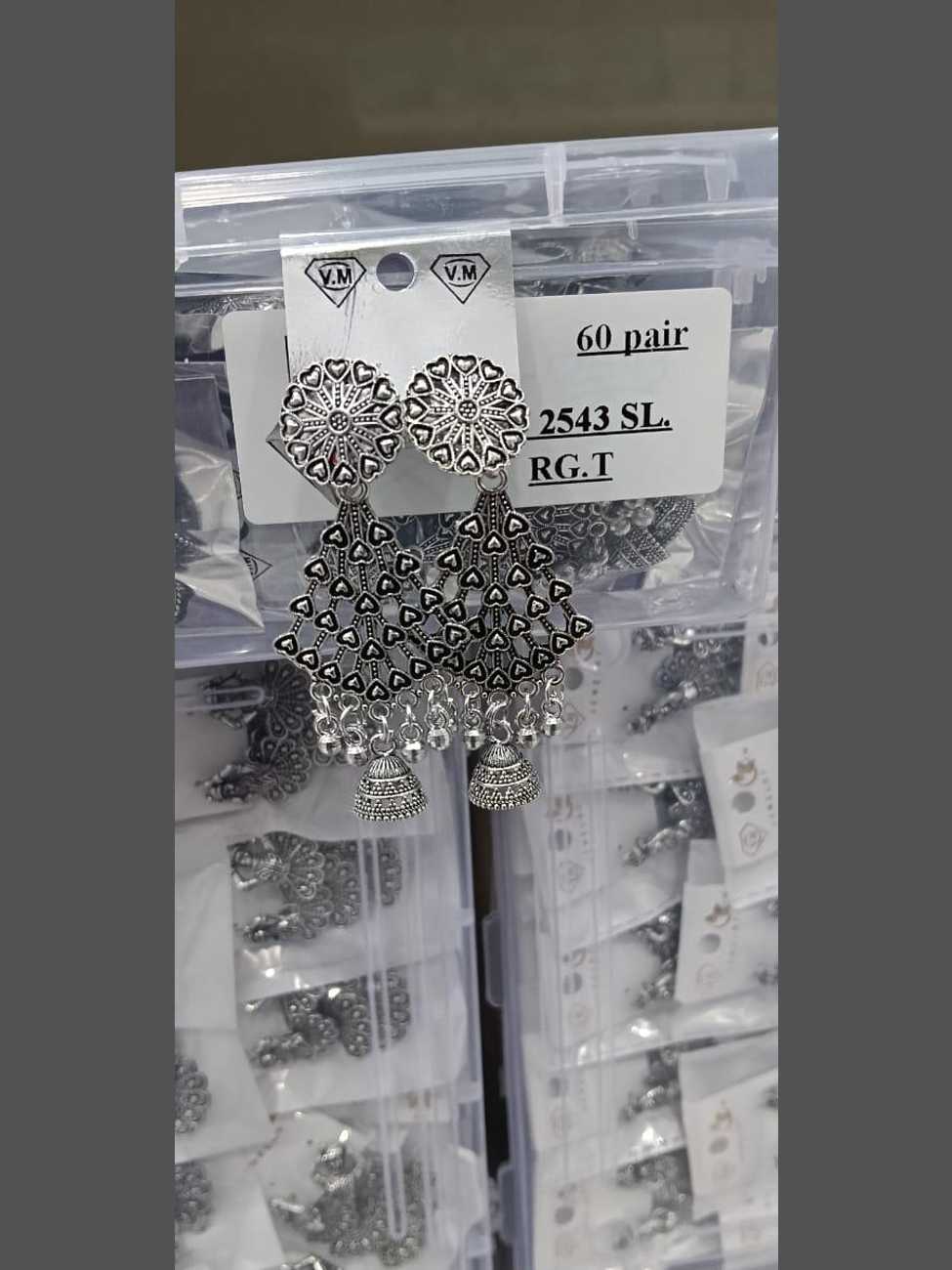 Oxidized silver earrings with a circular floral stud, a cascading heart-motif triangle body, and traditional jhumka drops.