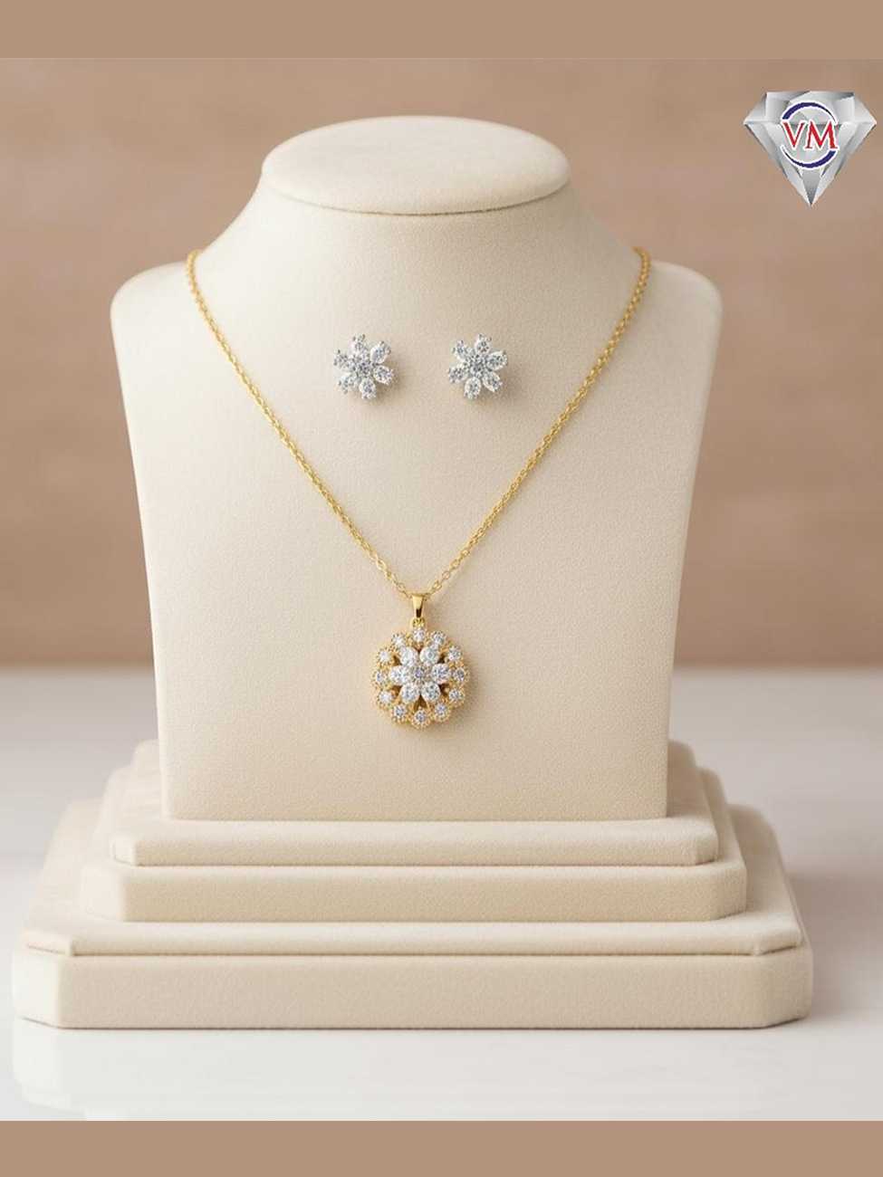 Intricate gold plated floral pendant and earrings set with concentric circles of brilliant-cut cubic zirconia.