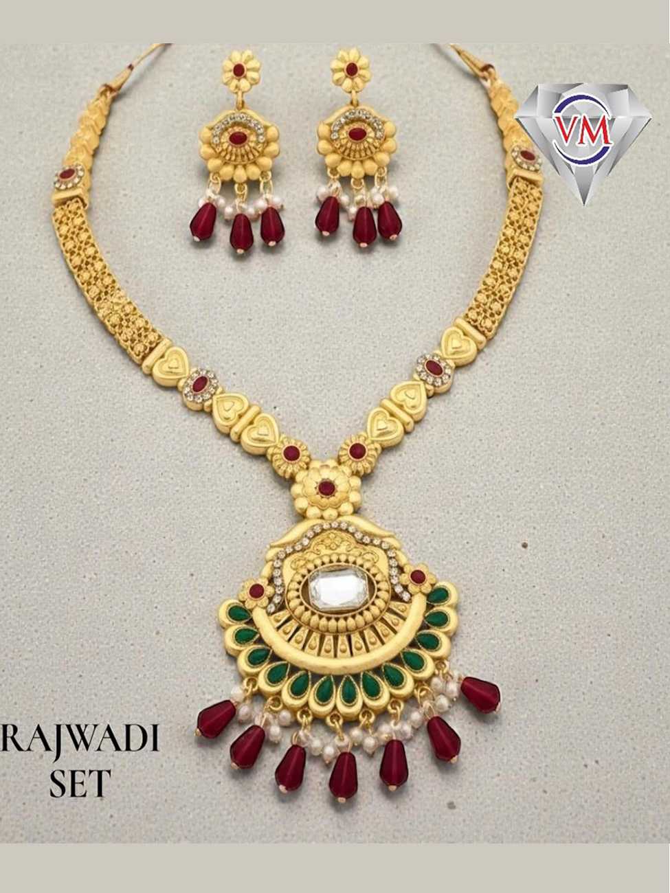 Gold finish Rajwadi necklace set with circular kundan pendant, green enamel detailing and ruby bead drops with matching earrings